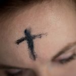 black cross on person's forehead